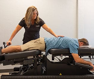 Chiropractor assisting a patient with spinal adjustment in Arizona