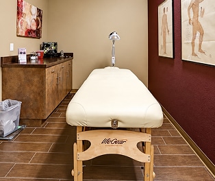 massage-room-enhanced 1 Chiropractor performing a therapeutic stretch for a young athlete