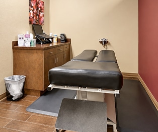 treatment-room-enhanced 1 Chiropractor performing a therapeutic stretch for a young athlete